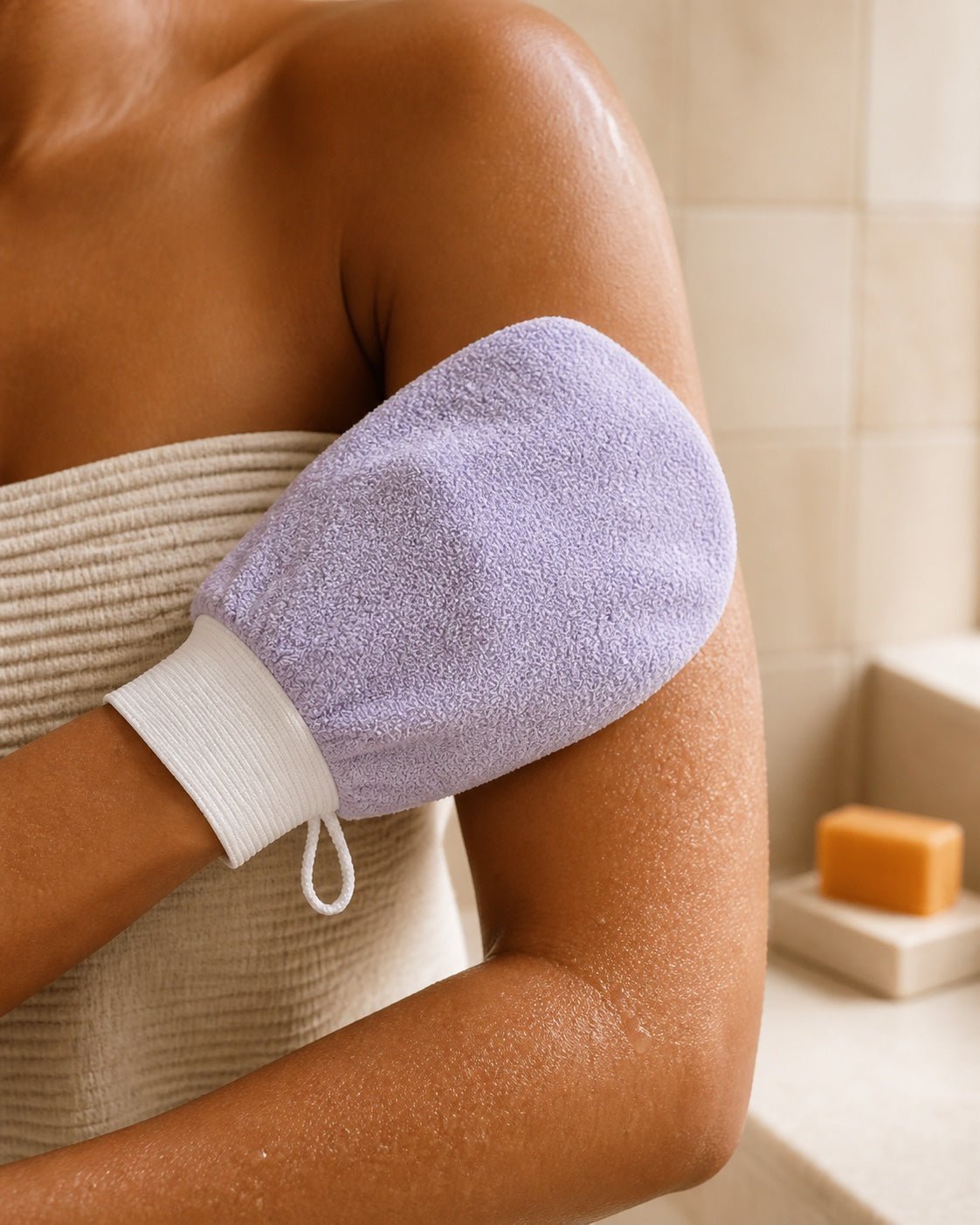 Woman gently exfoliating her upper arm with the lilac Haldayne mitt